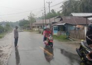 Personil Polsek Ampana Kota Bripka I Komang Budiasa Saat Melakukan Pengaturan Arus Lalulintas di Lokasi Banjir Kelurahan Malotong.