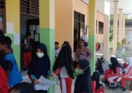 Kapolsek Ampana Kota Saat Mendampingi Vaksinasi Anak di SDN 9 Ratolindo.